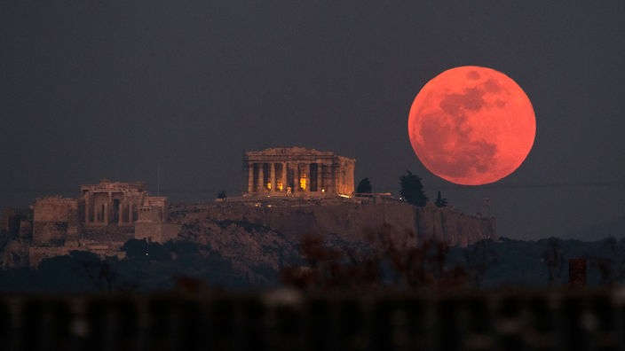Ein roter Supermond geht hinter dem Parthenon auf der Akropolis auf