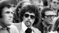 Paul Breitner mit Afrofrisur und Koteletten, er trägt Sonnenbrille und raucht Zigarre