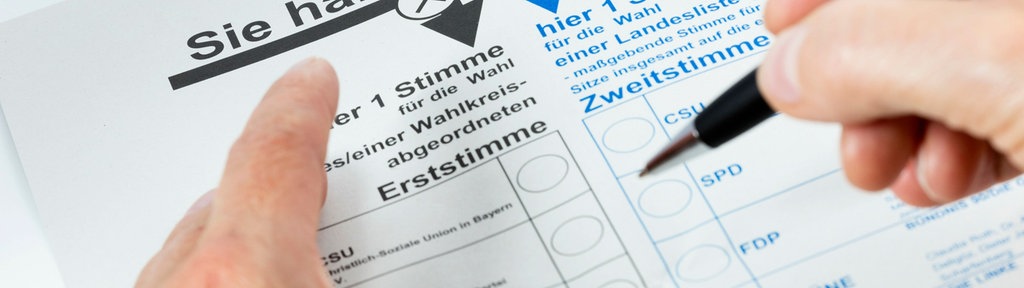 Zwei Hände und ein Wahlzettel mit der Aufschrift "Sie haben 2 Stimmen"