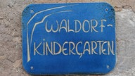 Ein blaues Schild mit der Aufschrift "Waldorfkindergarten"