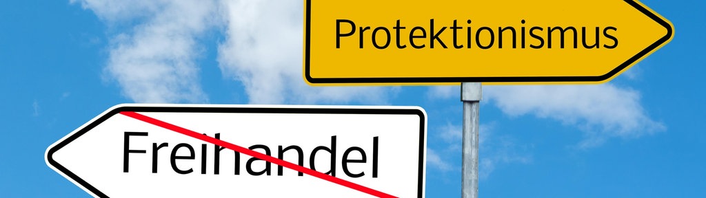 Neben einem Schild mit dem durchgestrichenen Wort Freihandel steht ein Schild mit dem Wort Protektionismus