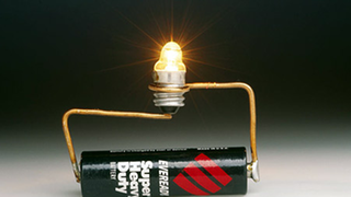 Eine Batterie ist durch zwei Drähte mit einer Glühbirne verbunden