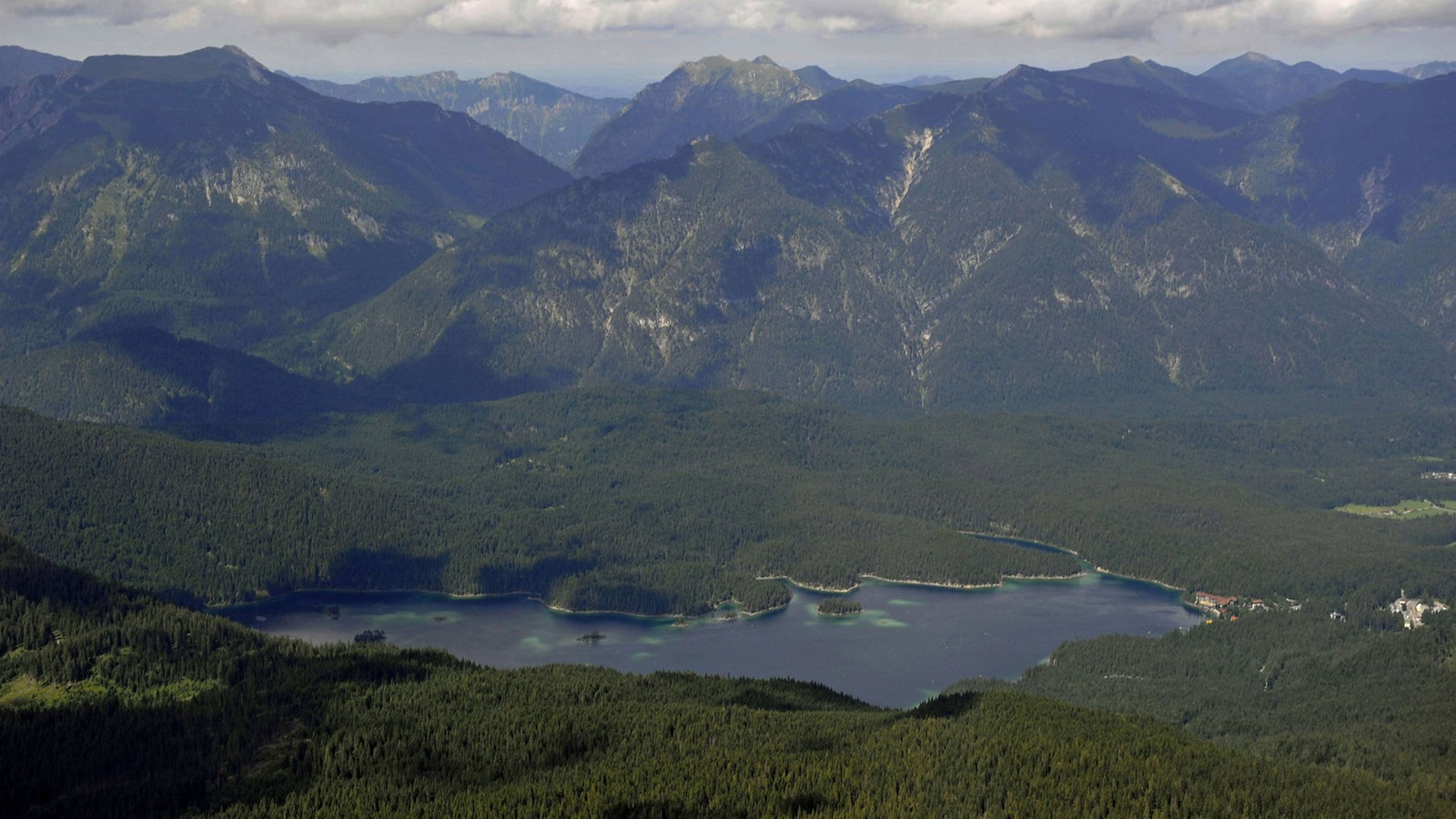 Der Eibsee unterhalb der Zugspitze zwischen bewaldeten Berghängen